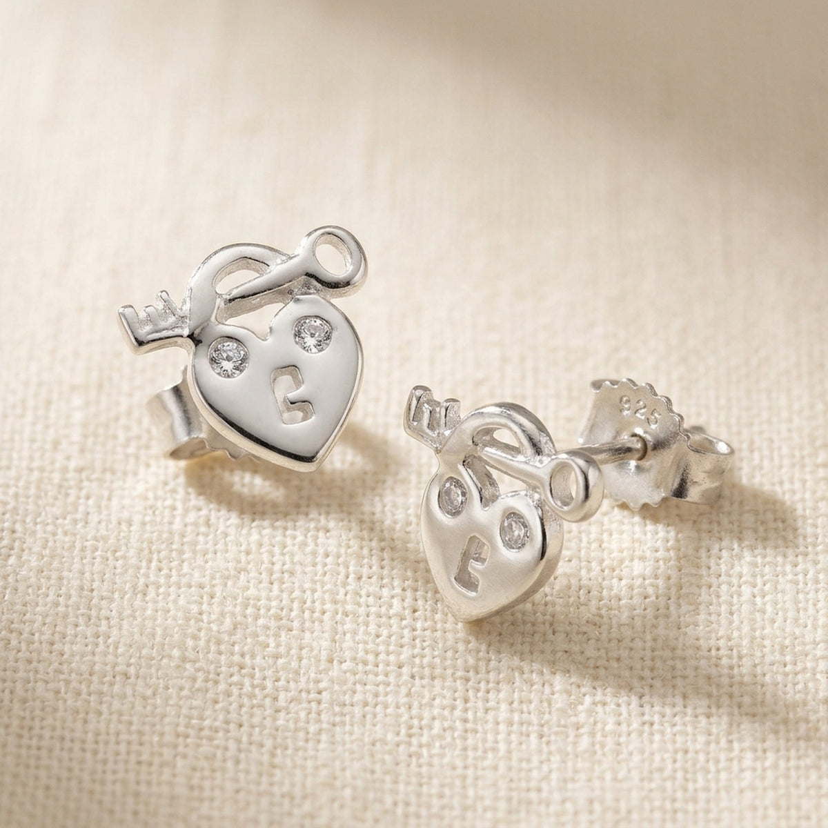 Ohrstecker Herz Schloss und Schlüssel mit Zirkonia glänzend – 925er Silber, 9 × 8 mm – Detailansicht des Ohrschmucks vor neutralem Hintergrund