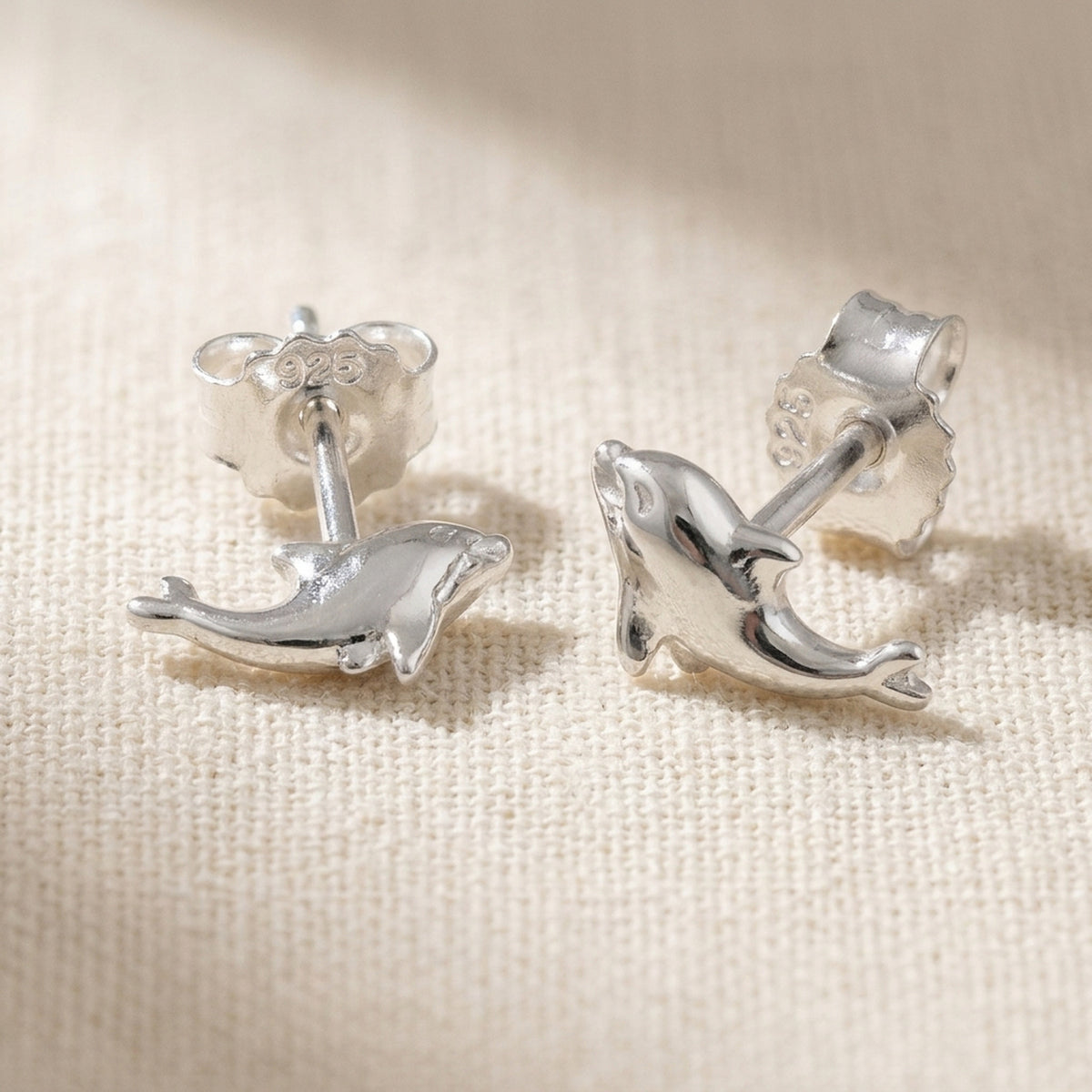Ohrstecker kleiner Delfin glänzend – 925er Silber, 8 × 4 mm – Detailansicht des Ohrschmucks vor neutralem Hintergrund