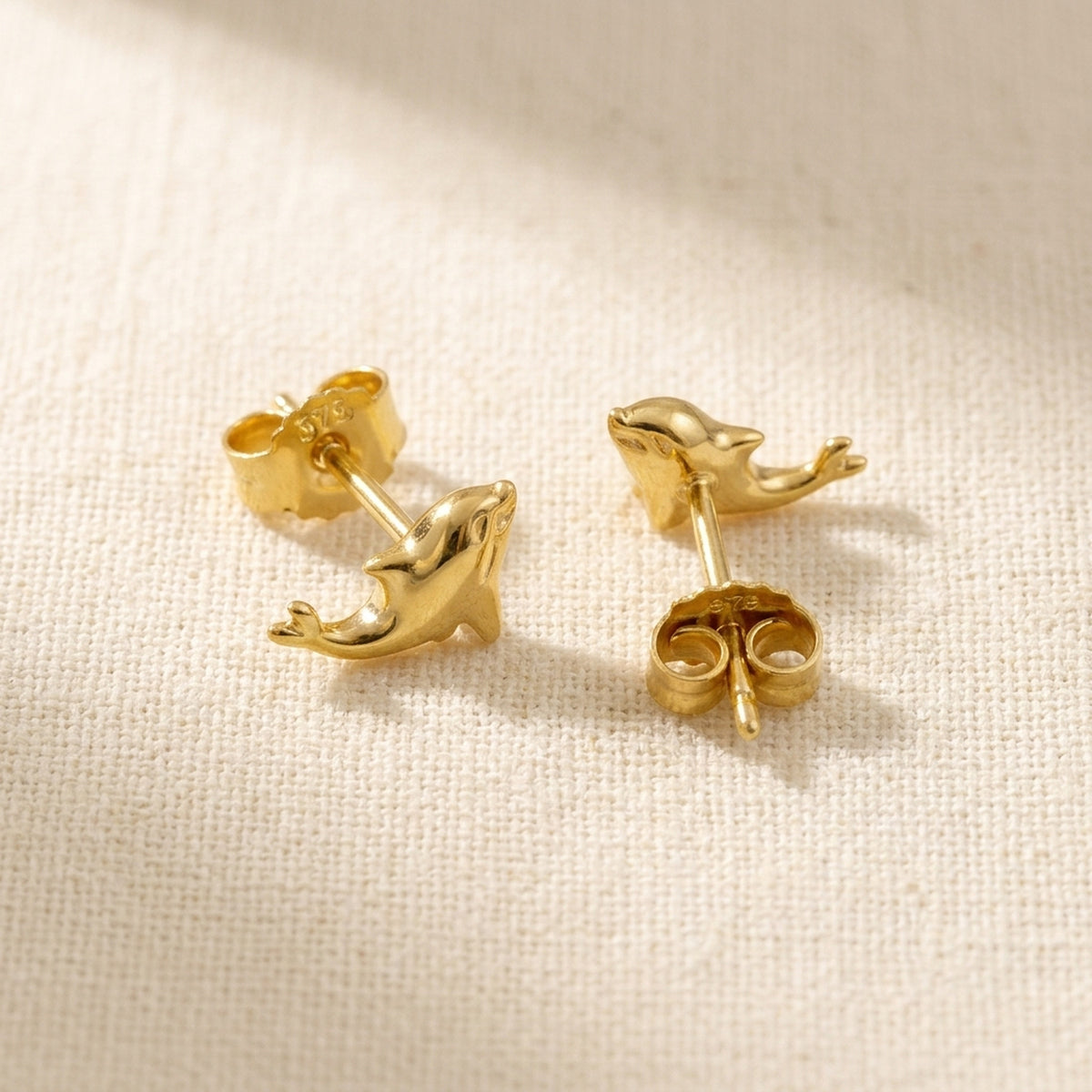 Ohrstecker kleiner Delfin glänzend – 375er Gold, 8 × 4 mm – Detailansicht des Ohrschmucks vor neutralem Hintergrund