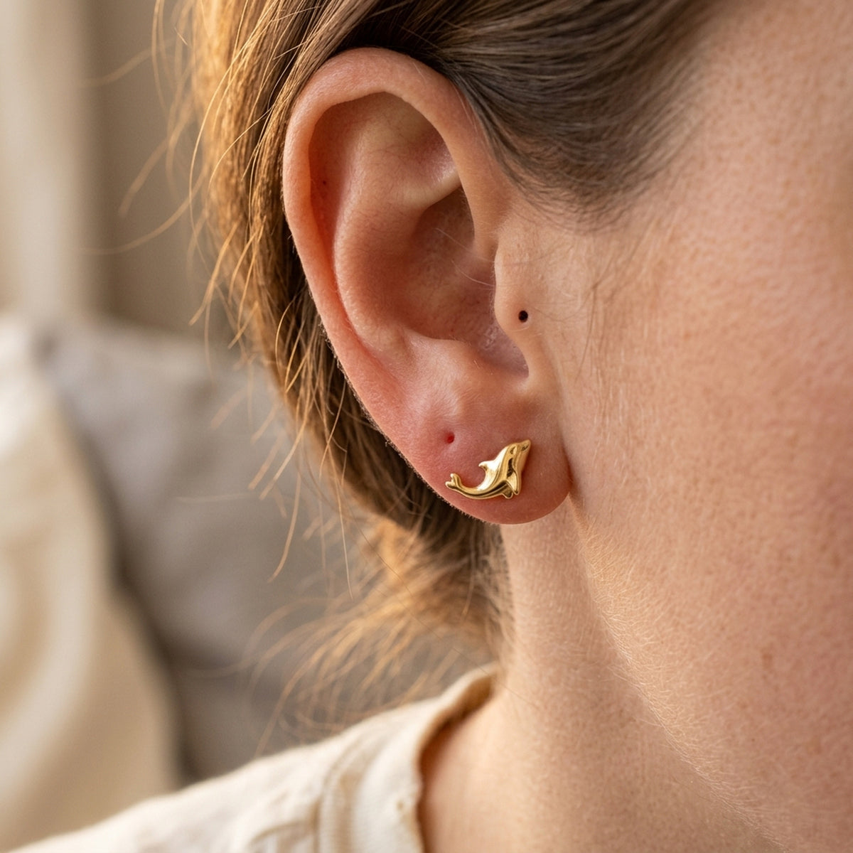 Ohrstecker kleiner Delfin glänzend – 375er Gold, 8 × 4 mm – am Ohr getragen, zweite Lifestyle-Aufnahme in anderer Perspektive