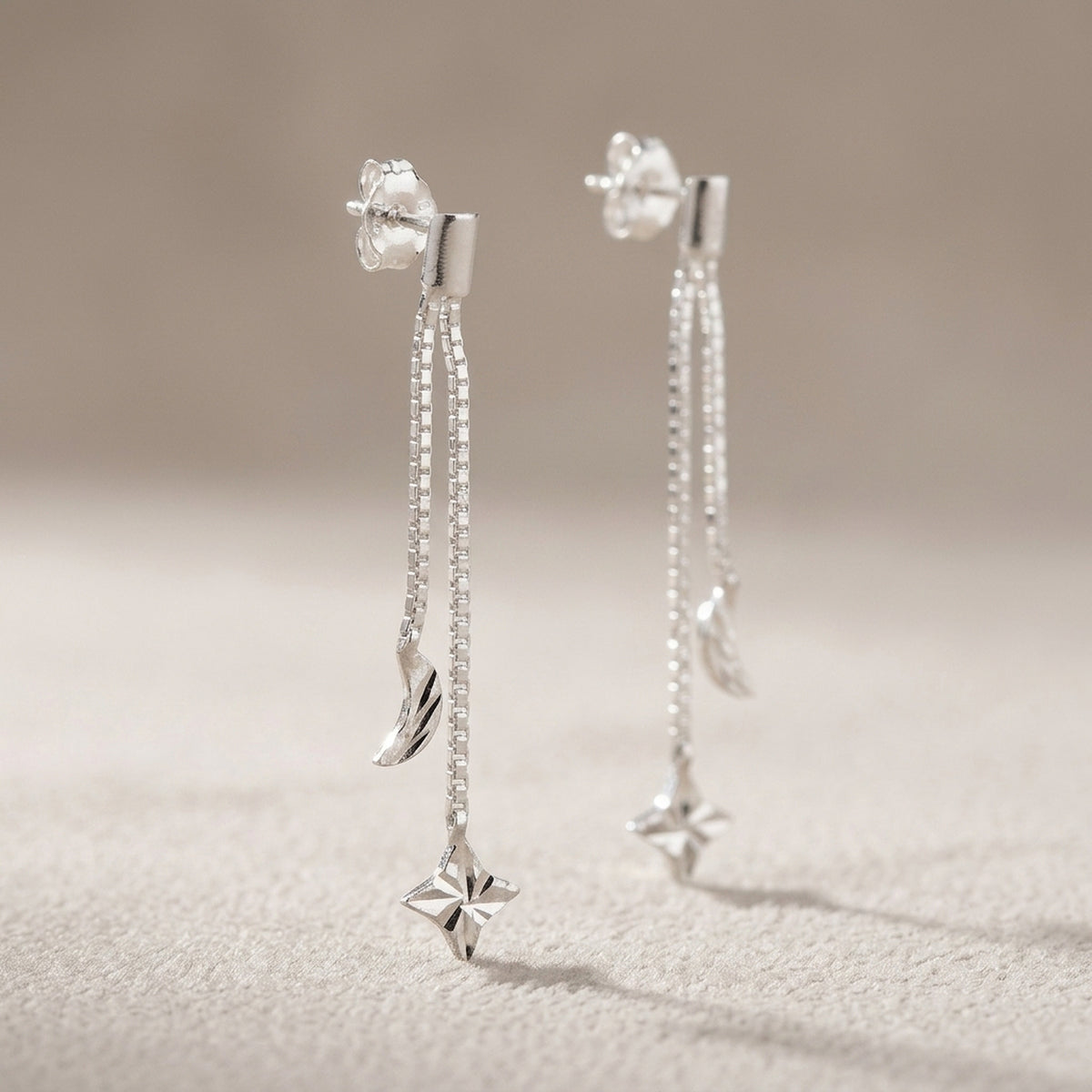 Langer Ohrstecker mit Kette, Mond und Stern – 925er Silber, 41 mm – Detailansicht des Ohrschmucks vor neutralem Hintergrund