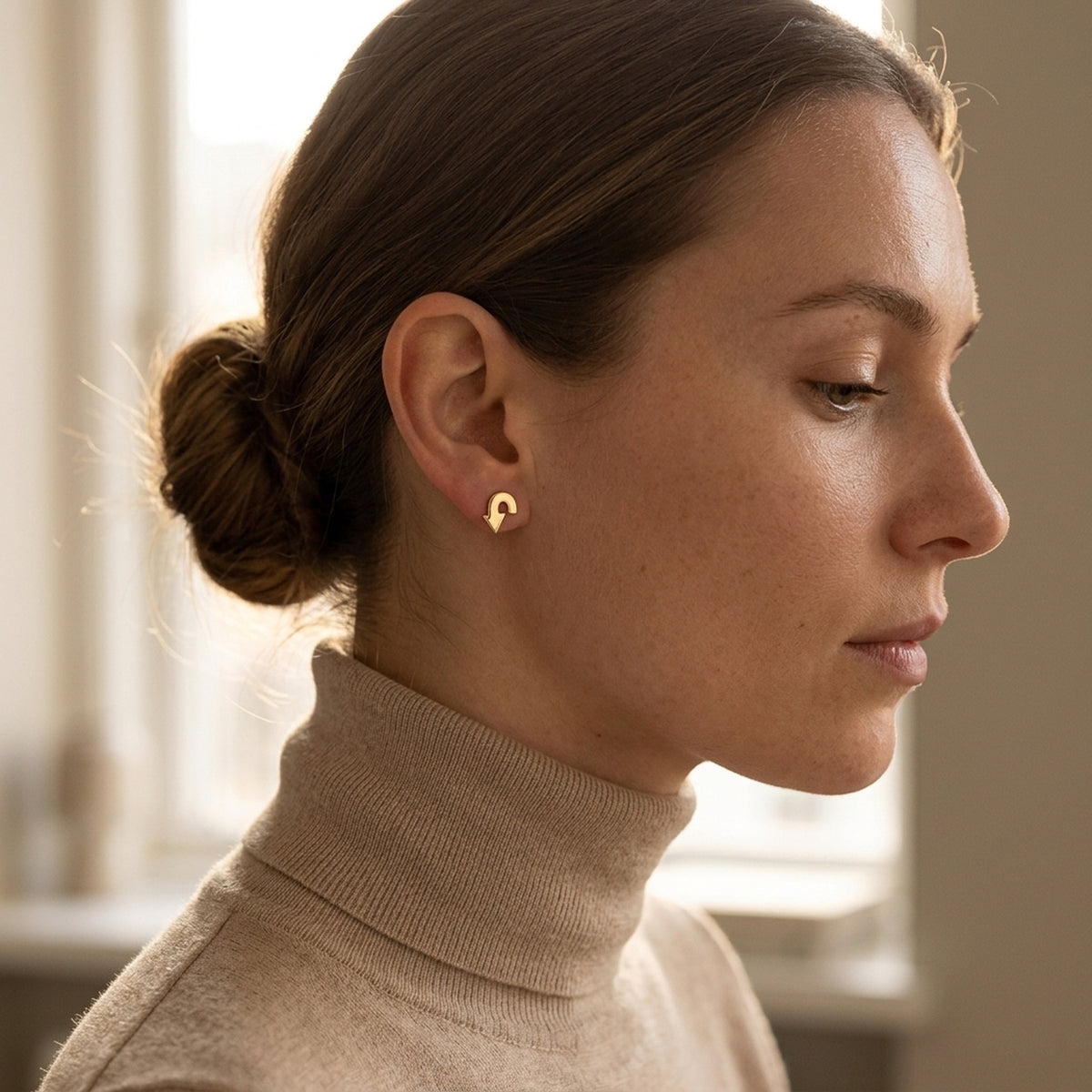 Ohrstecker Pfeil glänzend – 375er Gold, 6 × 5 mm – am Ohr getragen, natürliche Lifestyle-Aufnahme