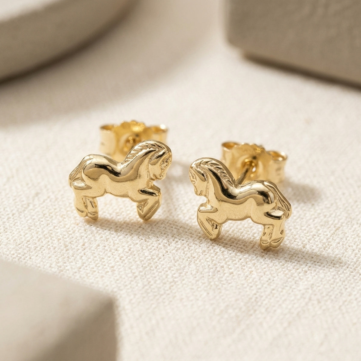 Ohrstecker Pferde glänzend – 375er Gold, 6 × 7 mm – Detailansicht des Ohrschmucks vor neutralem Hintergrund
