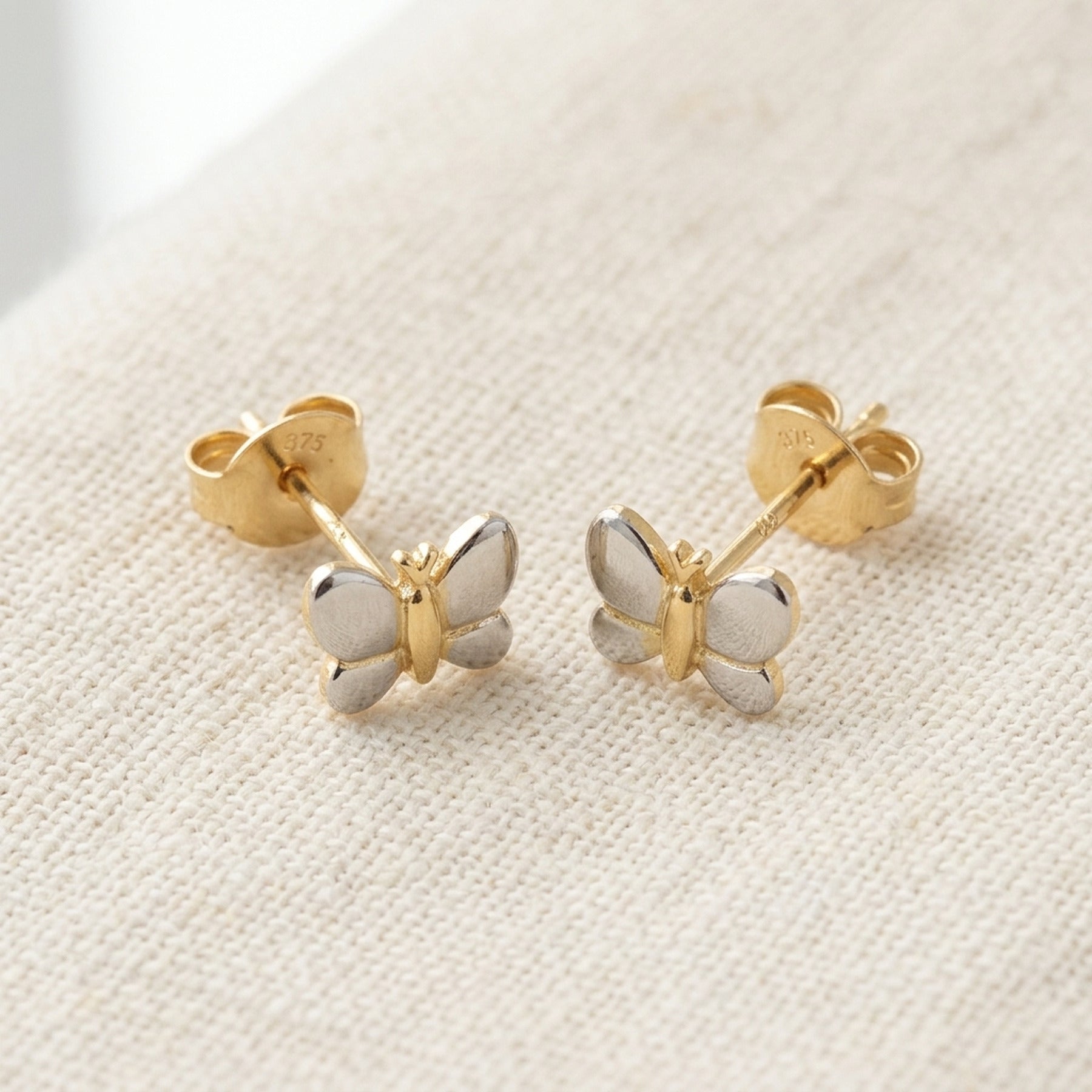 Ohrstecker Schmetterling bicolor glänzend – 375er Gold, 6 × 5 mm – Detailansicht des Ohrschmucks vor neutralem Hintergrund