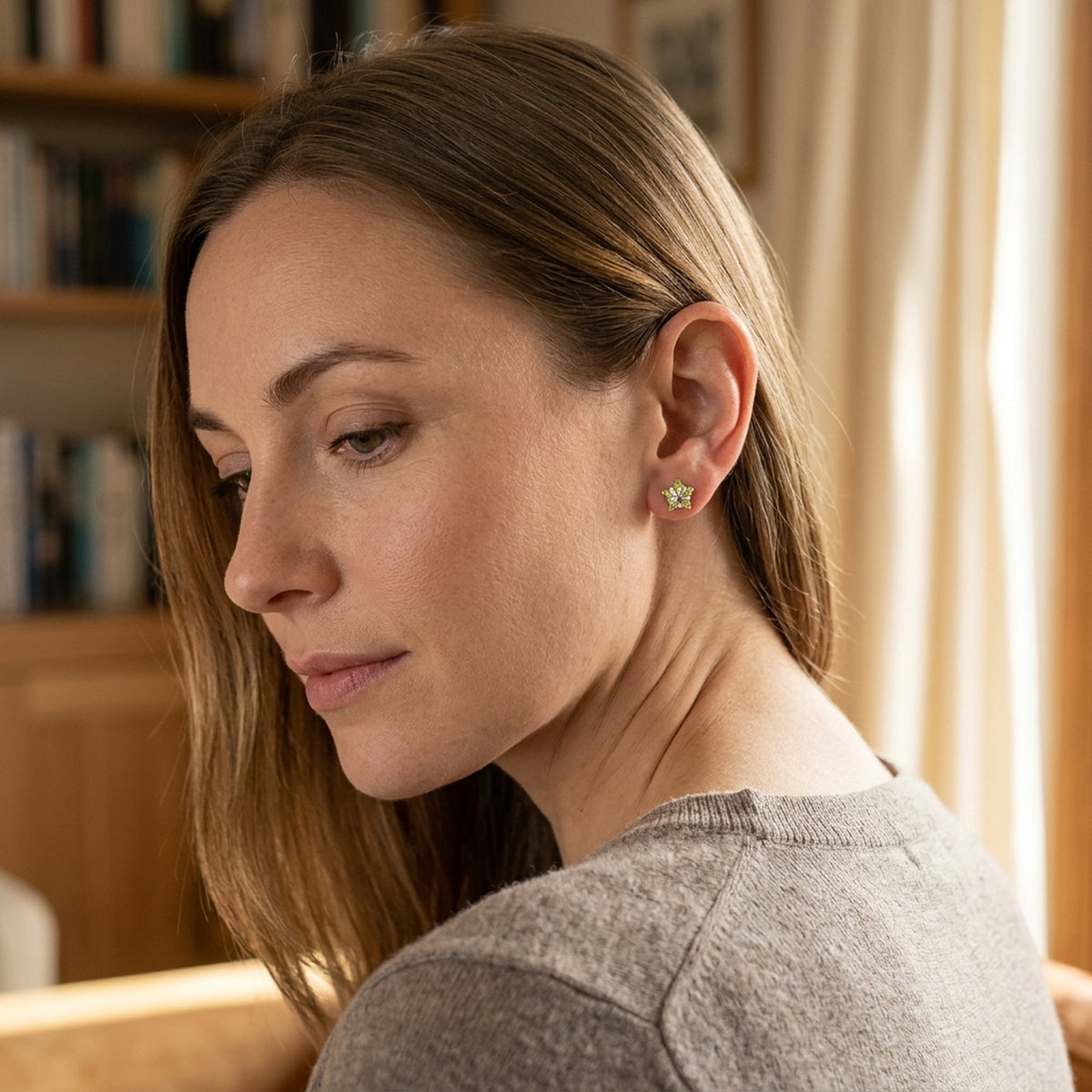 Ohrstecker Stern mit hellolivfarbenem Zirkonia – 925er Silber, 6 mm – am Ohr getragen, zweite Lifestyle-Aufnahme in anderer Perspektive