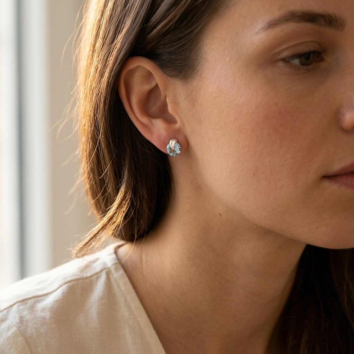 Ohrstecker mit synthetischem Aquamarin – 925er Silber, 7 × 6 mm – am Ohr getragen, zweite Lifestyle-Aufnahme in anderer Perspektive