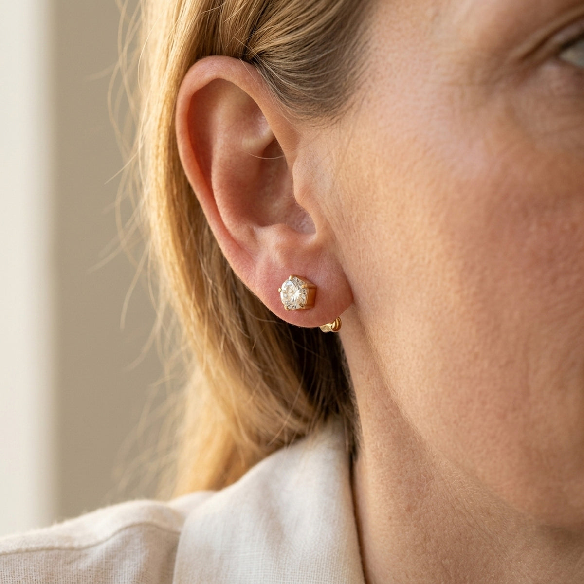Ohrstecker mit Zirkonia in Blumenform – 375er Gold, 4 mm – am Ohr getragen, zweite Lifestyle-Aufnahme in anderer Perspektive