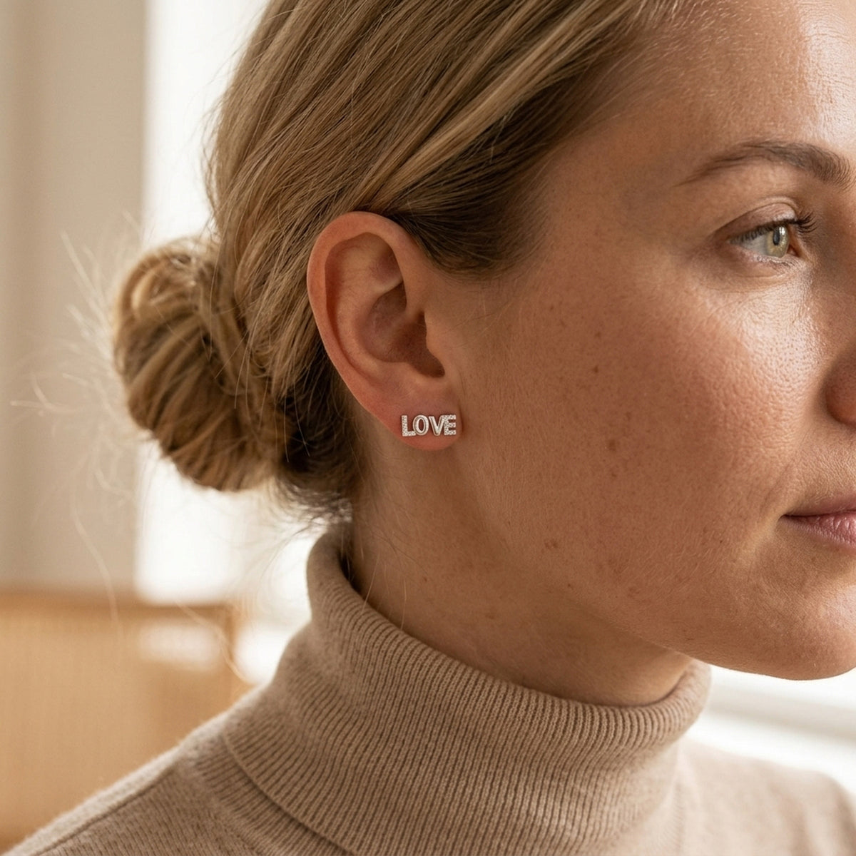 Ohrstecker LOVE mit Zirkonia – 925er Silber, 6 × 7 mm – am Ohr getragen, natürliche Lifestyle-Aufnahme