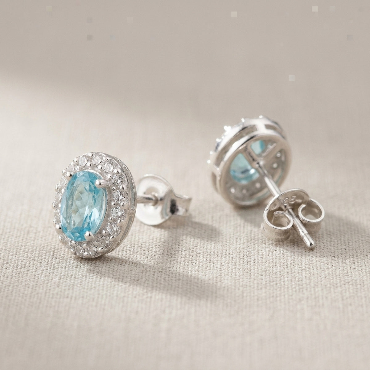 Ohrstecker mit weißen und hellblauen Zirkonia – 925er Silber, 9 × 7 mm – Detailansicht des Ohrschmucks vor neutralem Hintergrund