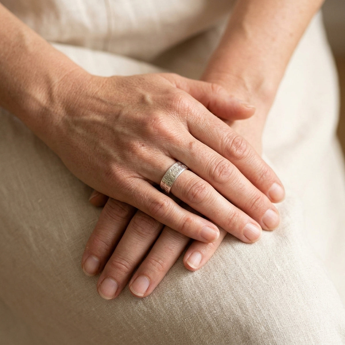 Ring mit Prägung LOVE HAS NO END – 925er Silber, 8 mm – an der Hand getragen, zweite Lifestyle-Aufnahme in anderer Perspektive
