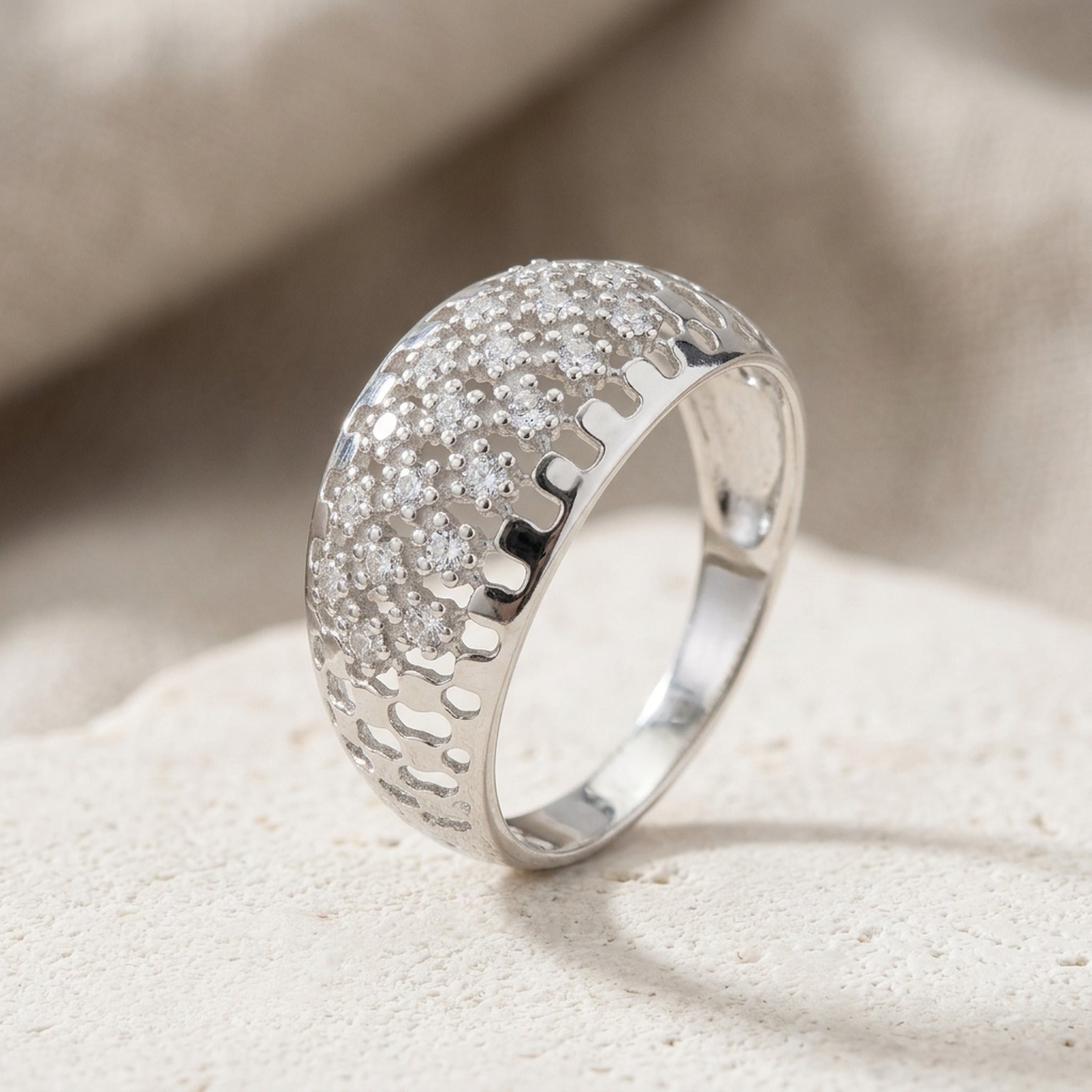 Ring mit vielen Zirkonia glänzend rhodiniert – 925er Silber, ca. 9 mm – Detailansicht des Rings vor neutralem Hintergrund