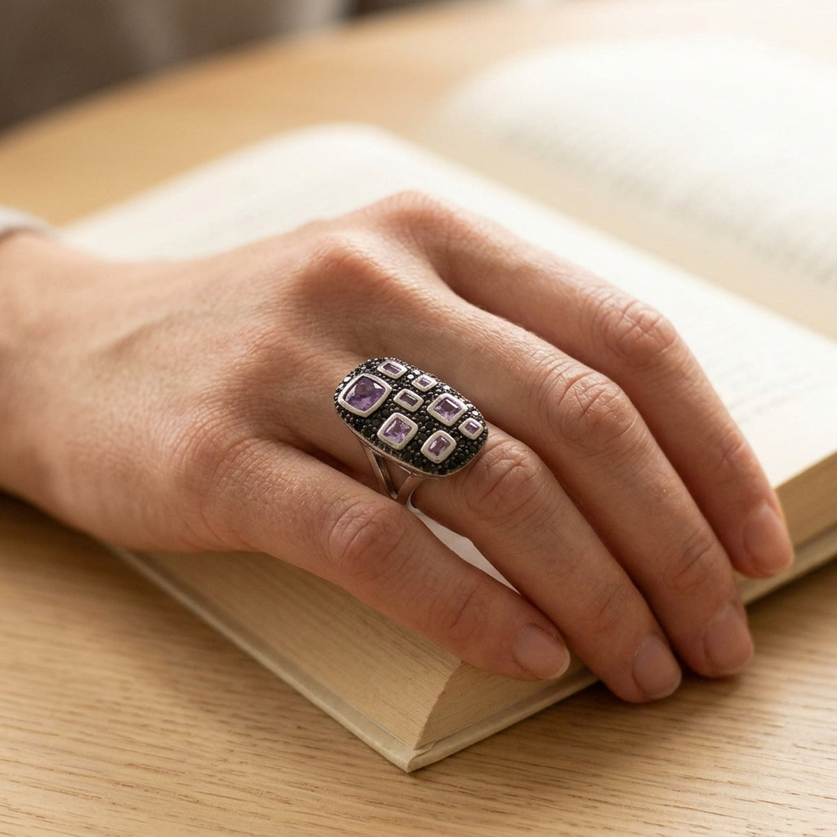Ring mit Zirkonia lila-schwarz glänzend rhodiniert – 925er Silber, 13 × 22 mm – an der Hand getragen, natürliche Lifestyle-Aufnahme
