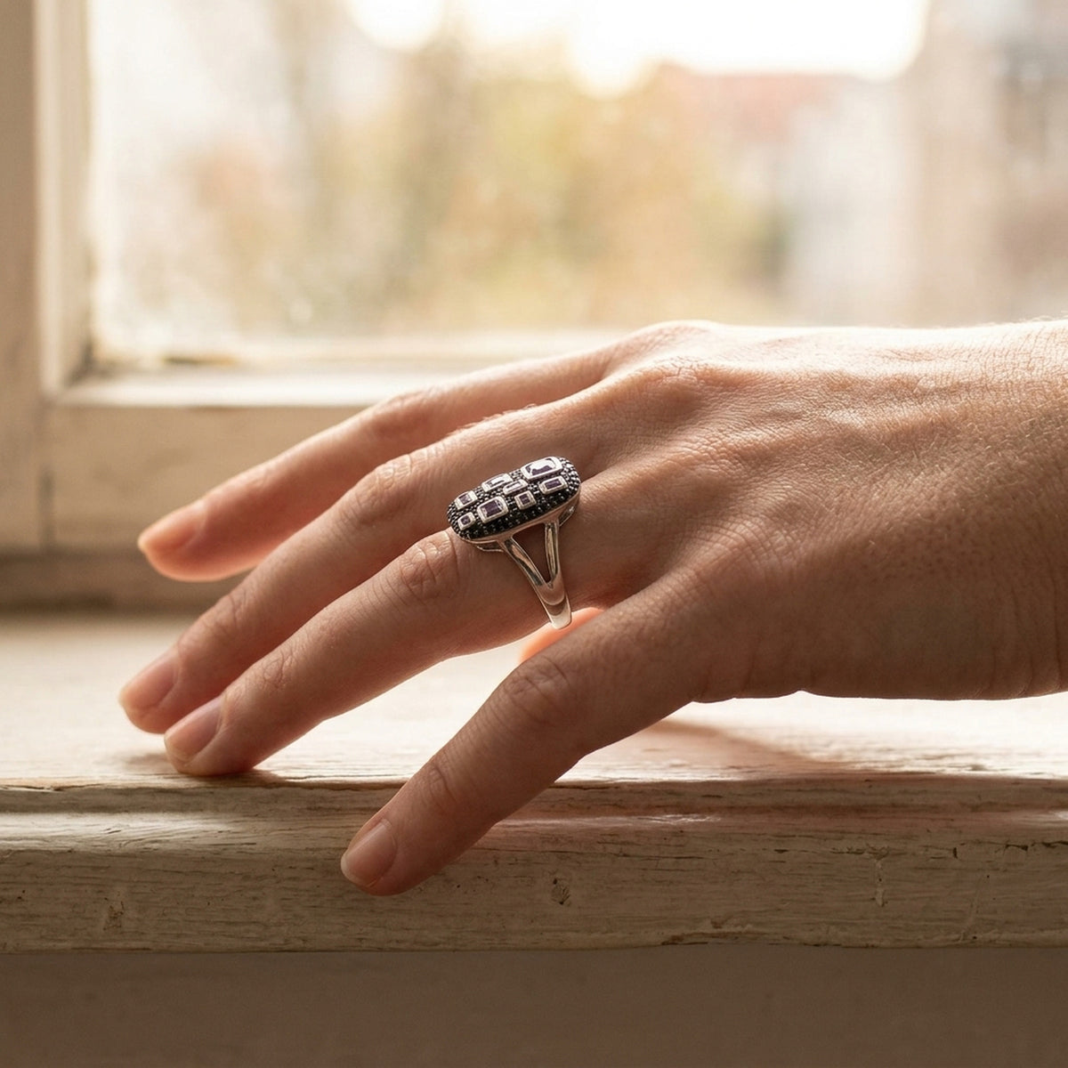 Ring mit Zirkonia lila-schwarz glänzend rhodiniert – 925er Silber, 13 × 22 mm – an der Hand getragen, zweite Lifestyle-Aufnahme in anderer Perspektive
