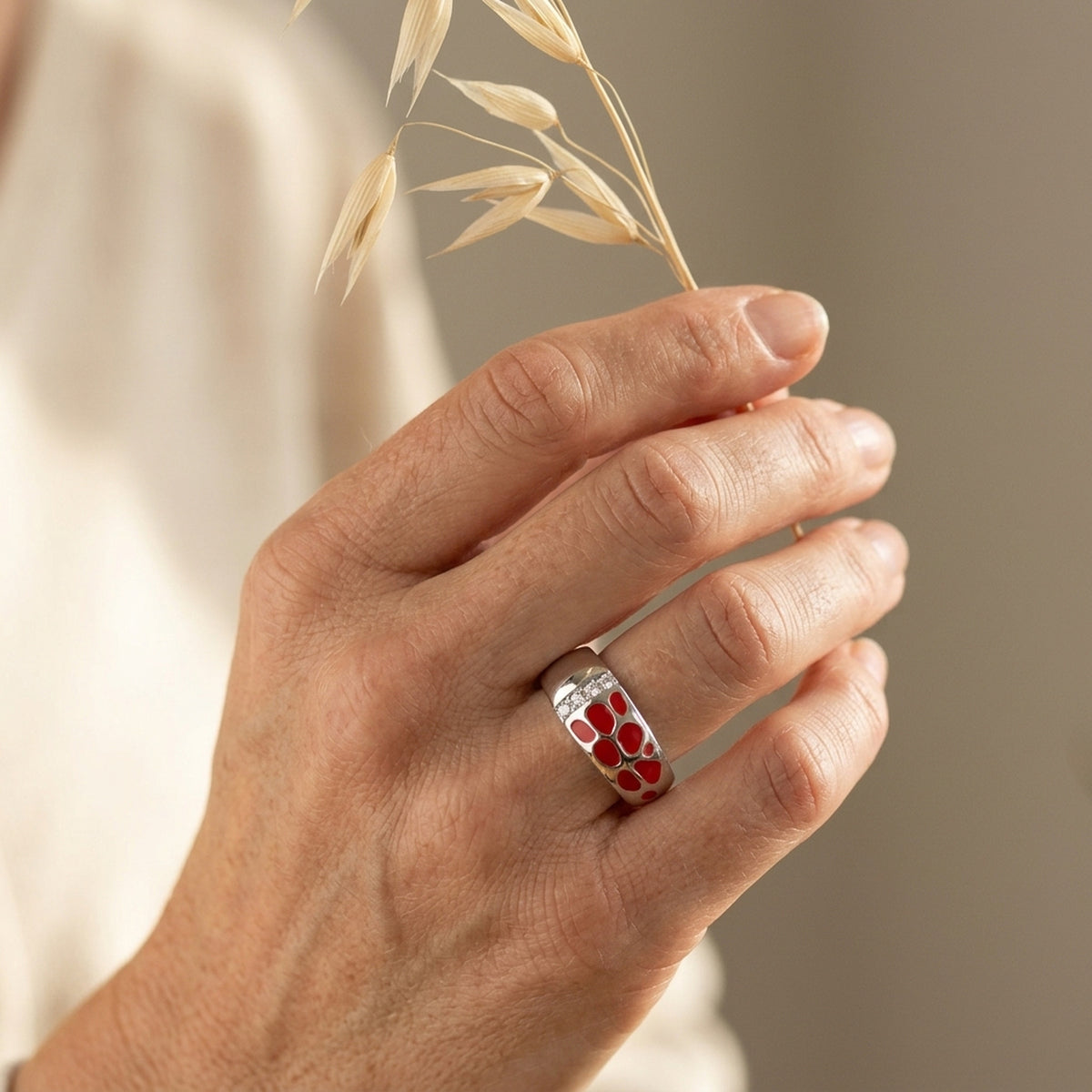 Ring mit roter Lackeinlage und 4 Zirkonia – 925er Silber, 7 mm – an der Hand getragen, zweite Lifestyle-Aufnahme in anderer Perspektive