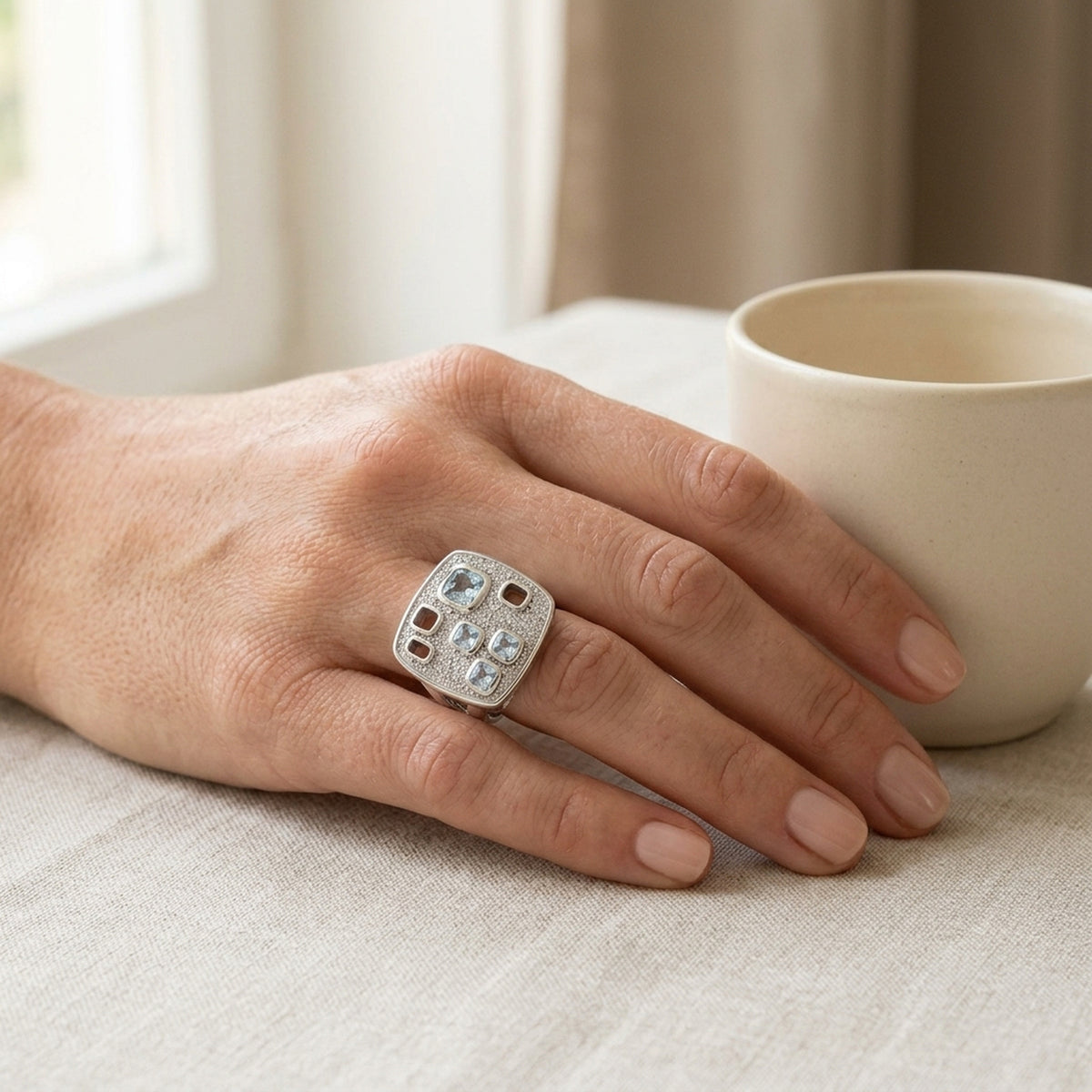 Ring mit aqua- und weißen Zirkonia im Viereck-Design – 925er Silber, 18 mm – an der Hand getragen, natürliche Lifestyle-Aufnahme