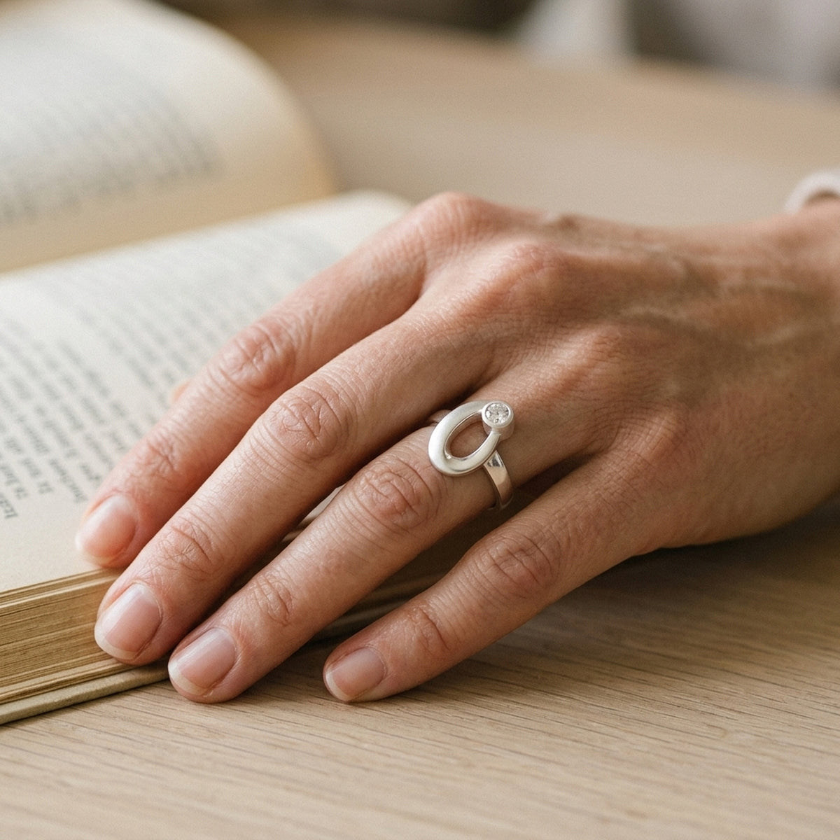 Ring mit gefasstem Zirkonia, matt-glänzend – 925er Silber, 9 mm – an der Hand getragen, natürliche Lifestyle-Aufnahme